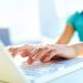 Close-up shot of a female learner typing on the laptop keyboard