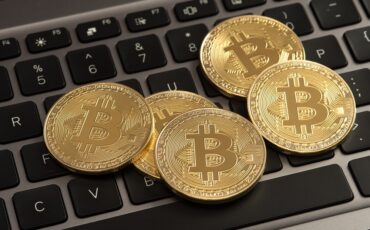 bitcoins-on-laptop-keyboard-stock-photos