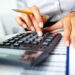 Photo,Of,Hands,Holding,Pencil,And,Pressing,Calculator,Buttons,Over